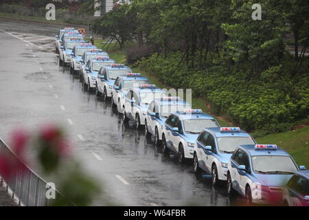 I taxi in coda fino a essere ricaricata in Pesanti rovesci di pioggia e forte vento causato dal tifone Mangkhut, la ventiduesima typhoon dell'anno, a fronte di un charing sta Foto Stock