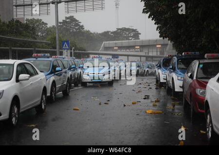 I taxi in coda fino a essere ricaricata in Pesanti rovesci di pioggia e forte vento causato dal tifone Mangkhut, la ventiduesima typhoon dell'anno, a fronte di un charing sta Foto Stock