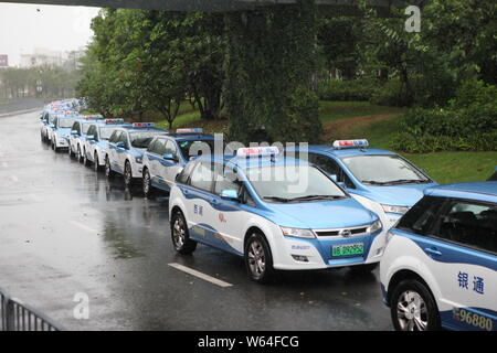 I taxi in coda fino a essere ricaricata in Pesanti rovesci di pioggia e forte vento causato dal tifone Mangkhut, la ventiduesima typhoon dell'anno, a fronte di un charing sta Foto Stock