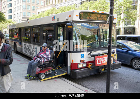 Chicago CTA bus accessibili con la donna sulla sedia a rotelle motorizzata in uscita sportello anteriore ramp Chicago IL USA Foto Stock