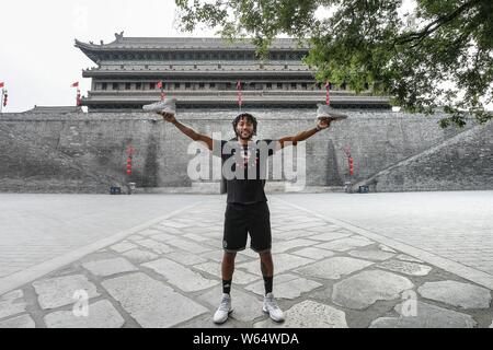 Stella NBA Derrick Rose del Minnesota Timberwolves in posa per una foto a Xi'an Circumvallation della dinastia Ming in Xi'an City, a nord-ovest della Cina di Shaanx Foto Stock