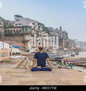 Insegnante di Yoga Ayush meditando sul fiume Gange a Varanasi a sunrise. Foto Stock