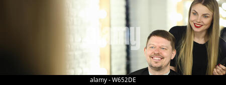 Parrucchiere sorridente e felice di client nel salone di parrucchiere Foto Stock