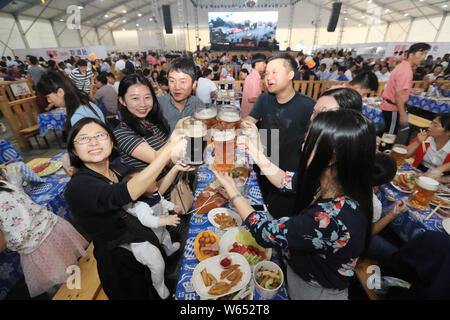 I turisti cinesi toast come essi godono di birra tedesca durante il tour della Cina di Oktoberfest Monaco di Baviera, uno dei più prestigiosi del mondo feste della birra, in K Foto Stock