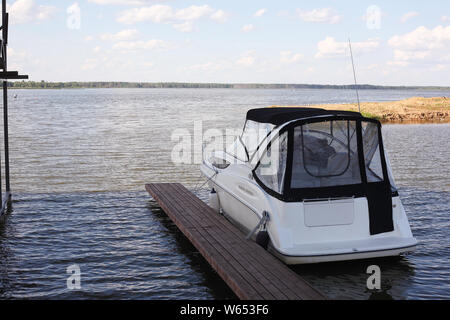 Barche parcheggio - Il moderno powerboat sul posto barca su nuvoloso il cielo di uno sfondo Foto Stock