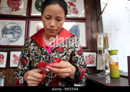 Folk Cinese artista Xie Jianqing rende la carta-tagli per la prossima festa Qixi o 'Double sette Festival", noto anche come il cinese il giorno di San Valentino Foto Stock