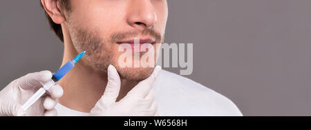 Medico di riempimento preparazione di sollevamento in viso maschile Foto Stock