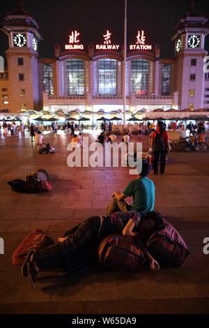 Passeggeri cinesi dormire e attendere per i loro treni presso la piazza della Stazione Ferroviaria di Pechino in Cina, 18 agosto 2018. Passeggeri cinesi sl Foto Stock