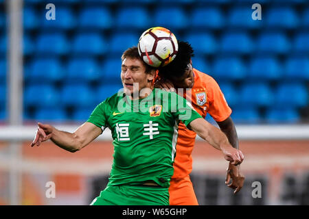 Il croato giocatore di calcio Nikica Jelavic, sinistra, di Guizhou Hengfeng capi la palla per effettuare un sorpasso contro il calcio brasiliano player Gil di Shandong Lunen Foto Stock