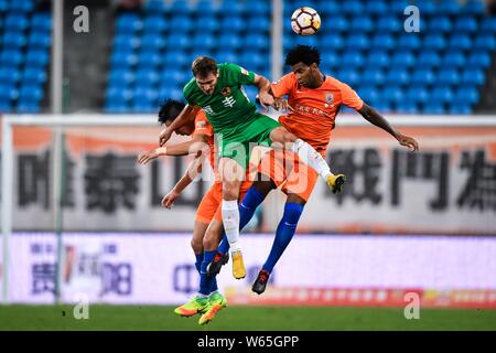 Il croato giocatore di calcio Nikica Jelavic, centro di Guizhou Hengfeng capi la palla per effettuare un sorpasso contro il calcio brasiliano player Gil di Shandong Lun Foto Stock