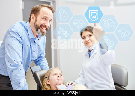 Dentista mostra kid scelta su un grande schermo touch screen in studio dentistico Foto Stock