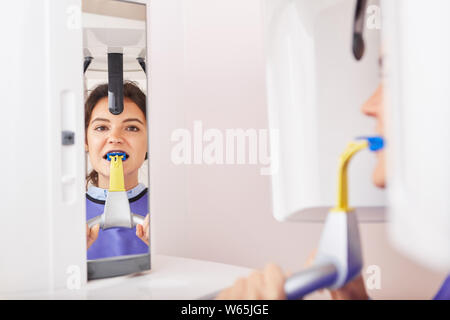 La donna come un paziente nella diagnosi della clinica dentale o pratica dentale durante i raggi x Foto Stock