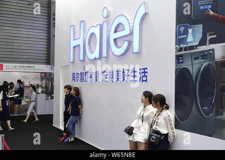 --FILE -- la gente visita lo stand della Haier durante una mostra a Shanghai in Cina, 26 luglio 2018. Chinese consumer electronics company Haier elettrodomestici Foto Stock