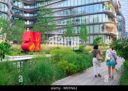 High Line New York City, vista di due donne che si avvicinano alla la Zaha Hadid 520 West 28th Street edificio mentre si cammina per la linea alta a Chelsea, New York, Stati Uniti d'America Foto Stock