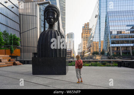 Chelsea New York, vista di un visitatore alla linea alta guardando l'enorme scultura mattoni casa di Simone Leigh, Chelsea, Manhattan, New York City, Stati Uniti d'America. Foto Stock