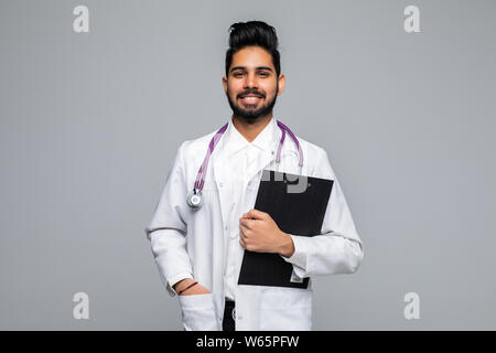 Ritratto di un allegro maschio indiano medico tenendo un diagramma di medici su sfondo grigio chiaro Foto Stock