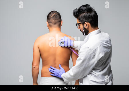 Giovane Maschio il controllo medico paziente con uno stetoscopio in ospedale Foto Stock