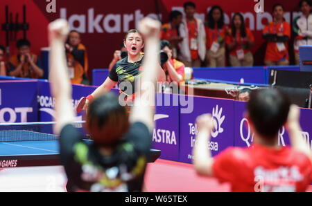 Chen Meng di Cina, indietro, celebra con i suoi compagni di squadra dopo aver sconfitto Cha Hyo-sim della Corea del Nord per le donne del tennis da tavolo finale del team durante il 2 Foto Stock