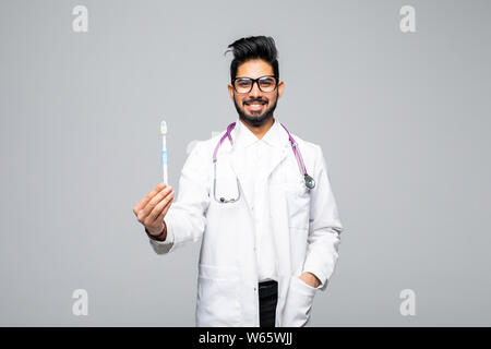 Closeup ritratto di un dentista tenendo uno spazzolino da denti, isolato su sfondo bianco con spazio di copia Foto Stock