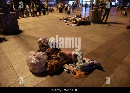 Passeggeri cinesi dormire e attendere per i loro treni presso la piazza della Stazione Ferroviaria di Pechino in Cina, 18 agosto 2018. Passeggeri cinesi sl Foto Stock