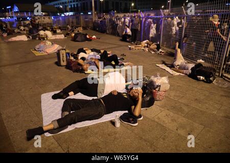 Passeggeri cinesi dormire e attendere per i loro treni presso la piazza della Stazione Ferroviaria di Pechino in Cina, 18 agosto 2018. Passeggeri cinesi sl Foto Stock