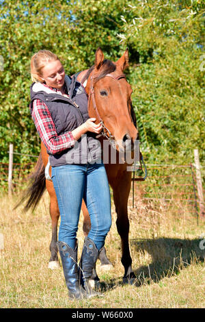 Giovane donna e American Quarter Horse, bay, cavallo western castrazione Foto Stock
