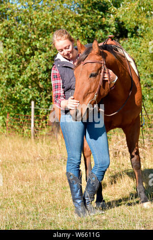 Giovane donna e American Quarter Horse, bay, cavallo western castrazione Foto Stock