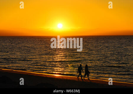 Passeggiata sulla Spiaggia Sunrise Foto Stock