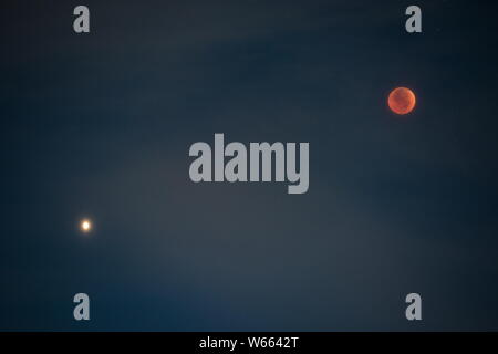 Vista la più lunga "sangue luna' eclissi di questo secolo, a destra che passa nel cono d'ombra della Terra e Marte nel cielo durante una lunare totale ce Foto Stock