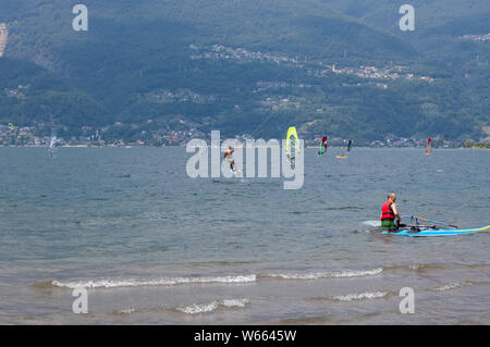 Il lago di Como, Italia - 21 luglio 2019. Sport acquatici: kitesurfisti e windsurf Surf il vento sulle onde su una soleggiata giornata estiva vicino a Colico, città Foto Stock