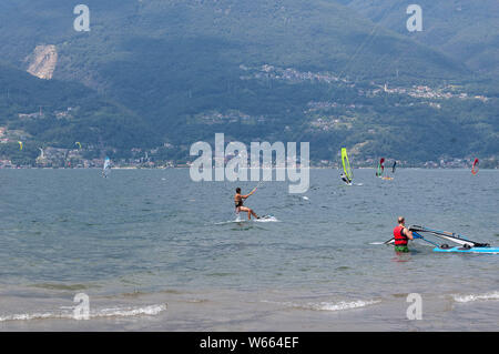 Il lago di Como, Italia - 21 luglio 2019. Sport acquatici: kitesurfisti e windsurf Surf il vento sulle onde su una soleggiata giornata estiva vicino a Colico, città Foto Stock