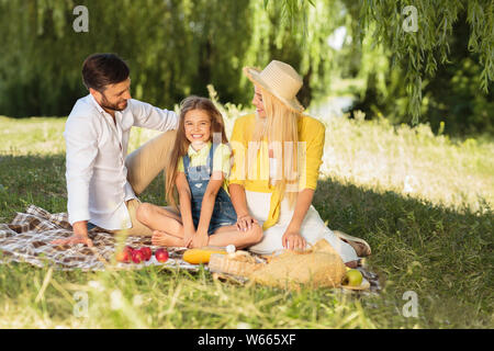 Giovane famiglia relax nel parco di erba Foto Stock