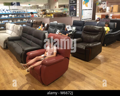 Locali residenti cinese di sonno o di riposo sui divani in un negozio di arredamento giapponese e home rivenditore accessori Nitori nella città di Wuhan, Cina centrale di Hube Foto Stock