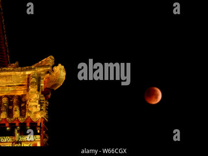 Vista la più lunga "sangue luna' eclissi di questo secolo che passa nel cono d'ombra della Terra, durante un'eclissi lunare totale in città Dingxi, Northwest Foto Stock