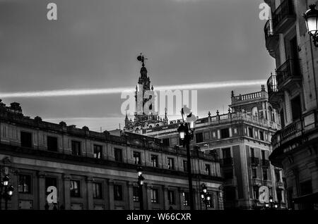 Immagine in bianco e nero di un chemtrail dietro la torre Giralda di Siviglia, Spagna Foto Stock