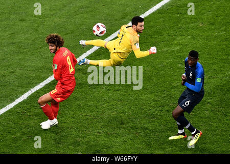 Il portiere Hugo Lloris della Francia, centro, colpisce la palla vicino al compagno di squadra Paolo Pogba e Marouane Fellaini del Belgio nella loro semifinale partita durante t Foto Stock