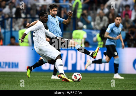 Rodrigo Bentancur, destra dell' Uruguay passa la palla contro Paul Pogba di Francia nel loro quarterfinal match durante il 2018 FIFA World Cup a Nizhny Foto Stock