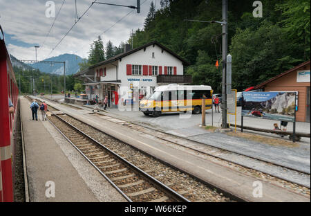 Versam, GR / Svizzera - 30. Luglio 2019: autobus pubblico resta in attesa presso la stazione ferroviaria di Versam per il treno per passare mentre molti turisti a piedi intorno Foto Stock