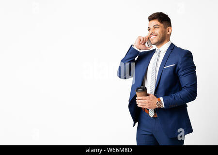 Imprenditore arabo parlando al cellulare e un caffè, isolato Foto Stock