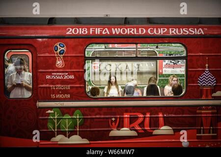 I passeggeri e gli appassionati di calcio di prendere un treno della metropolitana appositamente equipaggiato con calcio-decorazioni a tema per il 2018 FIFA World Cup a una stazione della metropolitana in Mos Foto Stock