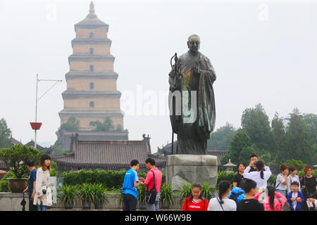 Una statua di bronzo di cinesi monaco buddista Xuanzang che diventa verde viene visualizzato nella parte anteriore del gigante della Pagoda dell'Oca Selvaggia o Grande Pagoda in Xi'an Foto Stock