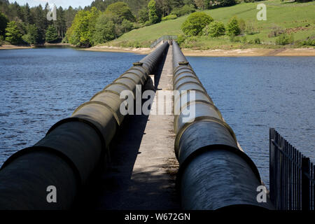 Twin acquedotti della tubazione al serbatoio Ladybower, la più grande azienda (6300 milioni di galloni) di tre bacini di stoccaggio di acqua nella Derwent Valley, il Picco D Foto Stock