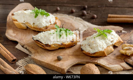 Pane tostato con il baccalà mousse sul tagliere di legno Foto Stock