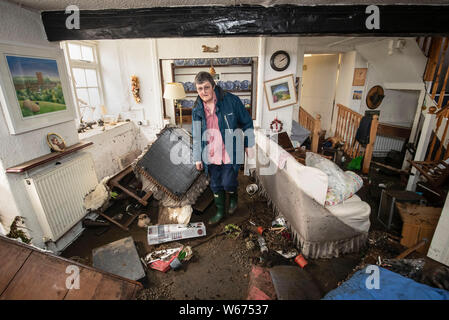 Rowena Hutchinson, proprietario del Red Lion Inn in Langthwaite, North Yorkshire, sorge nel soggiorno dopo la sua casa e pub sono state devastate da acqua di inondazione, dopo le parti della regione avevano fino a 82.2mm di pioggia in 24 ore il martedì. Foto Stock