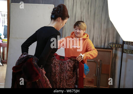 --FILE--26-anno-vecchia ragazza cinese Liang Xiaoqing da Pechino finisce i suoi capelli e il trucco prima che posano per una foto per marche di abbigliamento che bersagli el Foto Stock