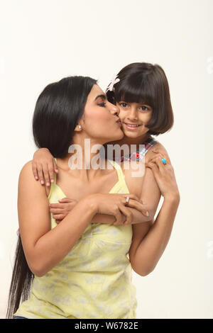 Donna baciare la figlia Foto Stock