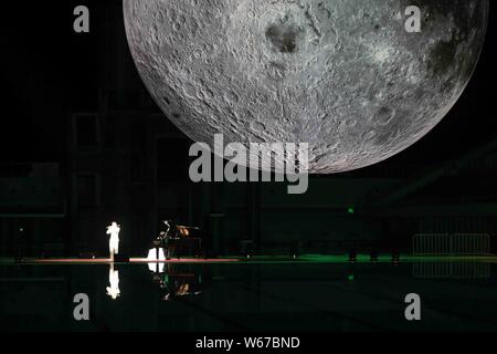 Ai visitatori di visualizzare un enorme luna modello durante una mostra sulla luna tenuto presso il Centro Acquatico Nazionale o 'Cubo Acqua" a Pechino in Cina, 8 luglio 2018. Un Foto Stock