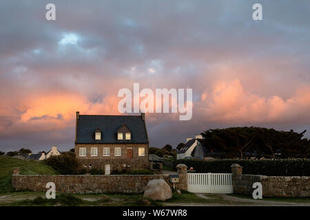 Bellissima casa tradizionale serata cielo colorato a Kerlouan, Meneham, Bretagna Francia Foto Stock