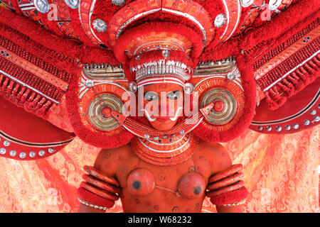 Danzatrice presso una tradizionale cerimonia Theyyam in un tempio di Kannur, India. Theyyam Kerala è più popolare rituale forma d'arte. Foto Stock