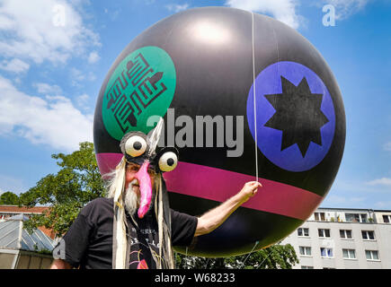 Dortmund / Germania, 22.Giugno 2019. Il Dortmund artista LEBENDIG LEO dimostra con un palloncino, in cui i simboli delle religioni del mondo sono dipinti, per una pacifica coesistenza delle religioni Foto Stock